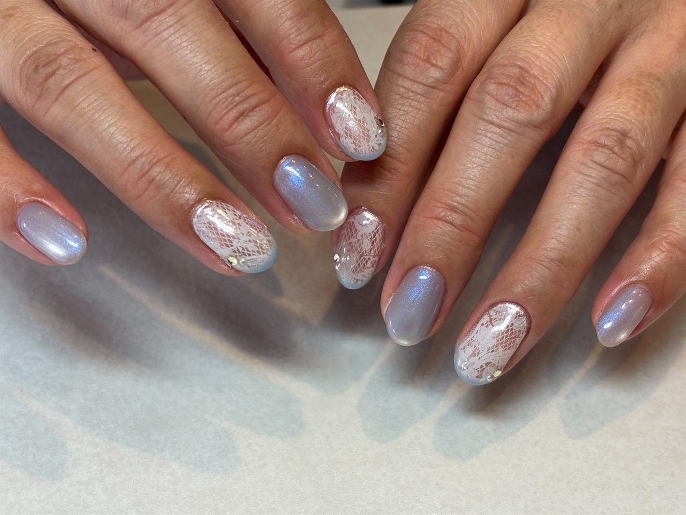 くすみブルーとパールを重ねたニュアンスネイル